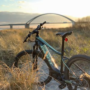 Fahrrad vor der Fehmarnsundbrücke im Sonnenuntergang