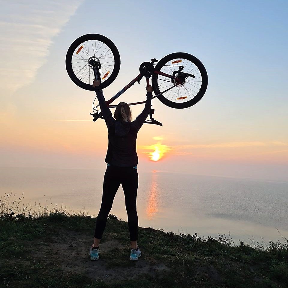 Frau mit Fahrrad in der Luft